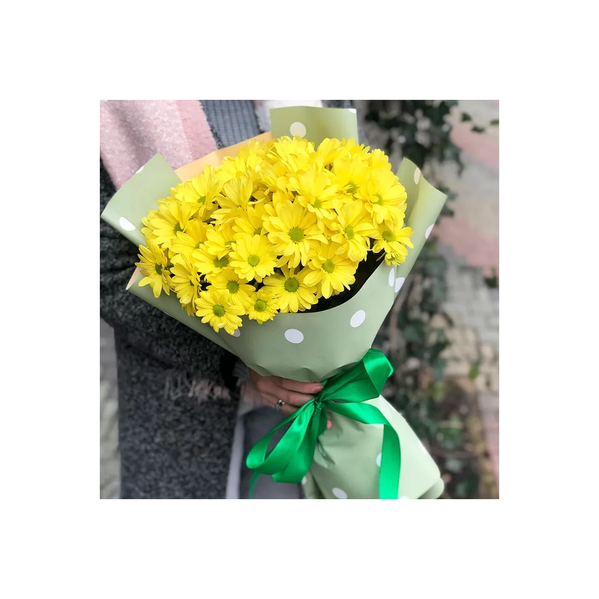 Yellow chrysanthemums in green paper photo